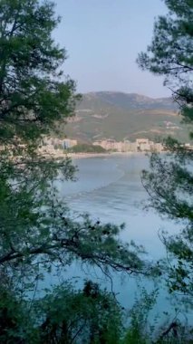 Bereketli ağaçların çerçevelediği huzurlu bir göl manzarası, doğanın güzelliğini sabah ışığında sergiliyor..