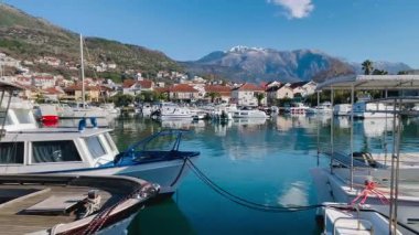Kıyı limanında demirli kruvazör ve rıhtımlar. Kasaba yansımaları ve dağ zeminiyle detaylı ipler, çamurluklar ve köpüklerle dolu.