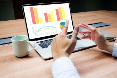 İş adamı, masadaki dizüstü bilgisayardaki slayt gösterisi sunumunu göstermek için elinizi kaldırın.