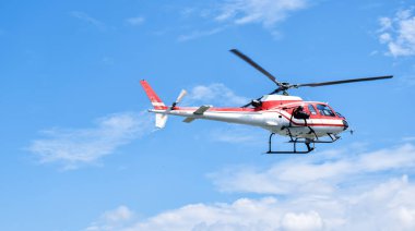 Mavi gökyüzüne kamera monte edilmiş bir helikopter.