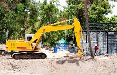 İnşaat alanında sarı kazıcı kazıyor