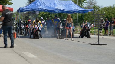 06-14-2025 - Bulgaristan 'ın Ruse kentinde düzenlenen Moto Rock Festivali sırasında motosiklet kalkış yarışının başlangıç çizgisinde yarışçılar mavi bir tepe altında hazırlanıyorlar.