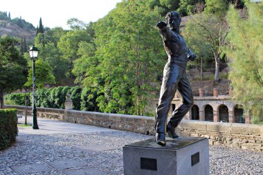 Flamenko dansçısı Mario Maya 'nın bronz heykeli Paseo de los Tristes, Granada, İspanya' da. Ağaçlarla çevrili ve akşam ışığı altında tarihi mimari.