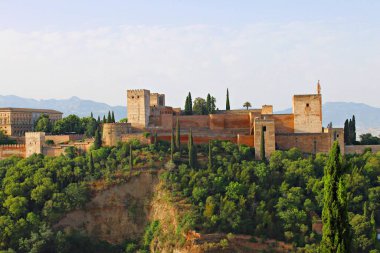 Mirador de San Nicolas 'tan Granada' daki Alhambra 'nın panoramik manzarası arka planda belli belirsiz Sierra Nevada dağları ile yemyeşil orman yamaçlarının üzerinde yükselen Nasrid saraylarını, kuleleri ve antik savunma duvarlarını gözler önüne seriyor..