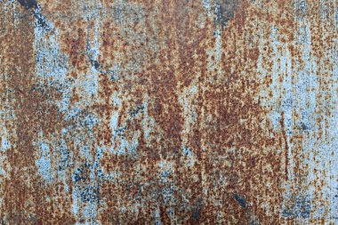 Paslı metal levha yüzeyi, soyulmuş mavi boya ve ağır aşınma dokusu, yıpranmış endüstriyel çürüme desenlerini, oksitlenmiş çelik detaylarını ve tasarım, malzeme çalışmaları ve yaratıcı doku uygulamaları için ideal grunge arkaplanı.