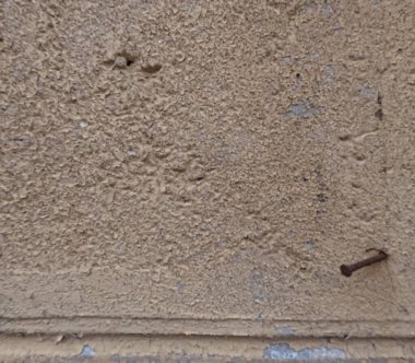 Eski yıpranmış duvar dokusu pürüzlü, pürüzlü alçı ve tek bir paslı çivi yüzeyde çürüme, aşınma ve eskimiş materyaller gösteriyor. Grunge arkaplanı mimari dokular, klasik tasarımlar ve ticari kullanım için idealdir