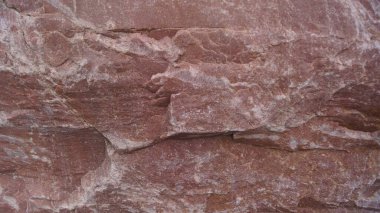 Kırmızı ya da kırmızımsı kahverengi kumtaşından pürüzsüz, düzgün bir yüzeye yakın çekim, ince doğal çizgiler ve arka plan için temiz, topraksı bir doku göstermektedir..