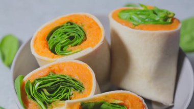 Tatlı patates ve ıspanakla sarılmış vegan tortilla, gri arka plan. Vejetaryen yemekleri pişirmek.