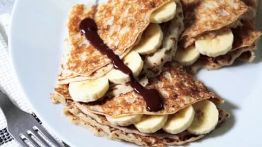 Beyaz tabakta muzlu ve çikolatalı ince krepler..