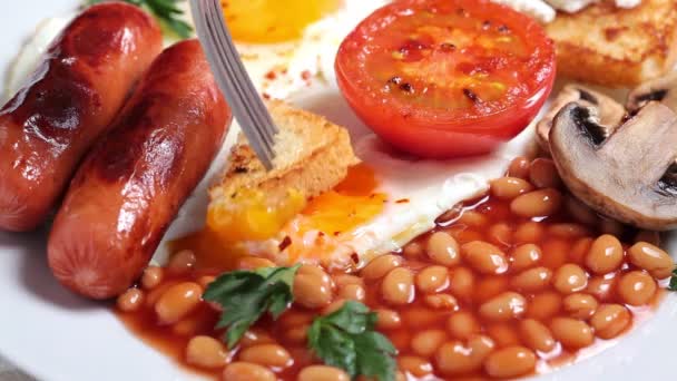 Englisches Frühstück mit Würstchen, Bohnen, Spiegeleiern, Toast, Pilzen und Tomaten. Englisches Frühstückskonzept. — Stockvideo