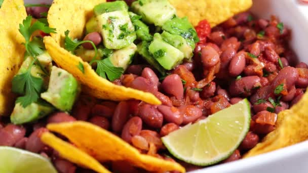 Babsaláta avokádóval és nachosszal fehér ételben. Mexikói élelmiszer-koncepció. — Stock videók