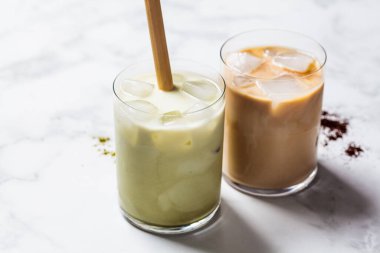 Soğuk yaz içkileri konsepti. Buzlu latte kibrit ve cam bardakta buzlu kahve, beyaz arka plan..