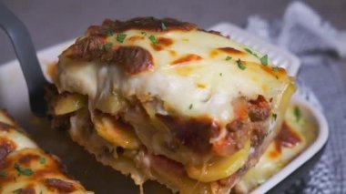 Geleneksel Yunan musakkası - peynirli patates ve etli güveç, koyu arkaplan. 