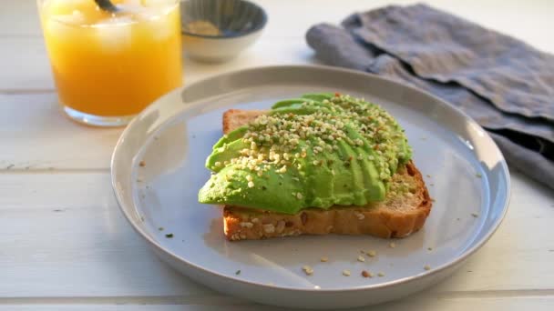 Avocado toast met hennepzaad. Veganistisch voedselconcept. — Stockvideo