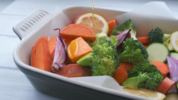 Verduras cortadas cruas - batatas doces, abobrinha, brócolis e cenouras na assadeira. Cozinhar legumes para assar no forno. — Vídeo de Stock