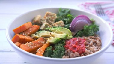 Fırında sebze, avokado, tofu ve karabuğday kasesi. Lahanalı vejetaryen öğle yemeği salatası, fırında tatlı patates, tofu, karabuğday ve avokado.. 