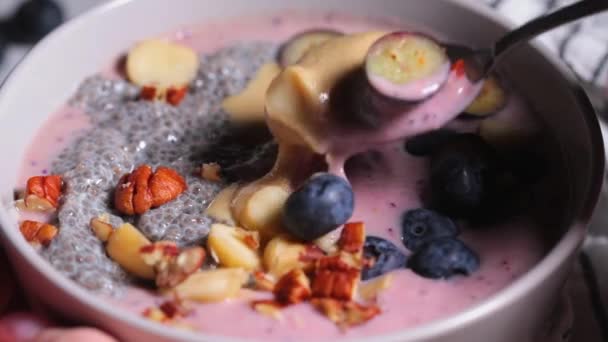 Acai smoothie bowl with chia seeds, berries, nuts and peanut butter. — Stock Video