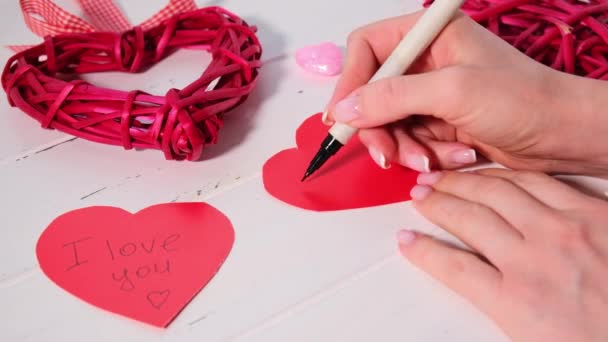Frauenhände basteln rote Karten für den Valentinstag. Valentinstag-Konzept. — Stockvideo