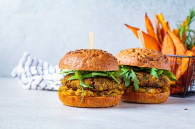 Roka soslu vejetaryen mercimek burger, hardal sosu, taze sebze ve patates kızartması. Vejetaryen gıda konsepti.