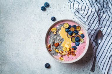 Chia tohumlu, böğürtlenli, fındıklı ve fıstık ezmeli Acai kasesi. Sağlıklı kahvaltı kavramı.