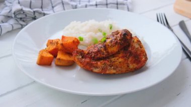 Fırında tavuk göğsü, pilav ve beyaz tabakta tatlı patates. Diyet gıda konsepti.
