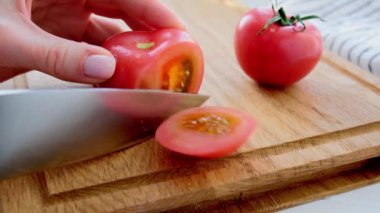 Tahtada bıçakla taze domates doğramak. Sebze pişirme.