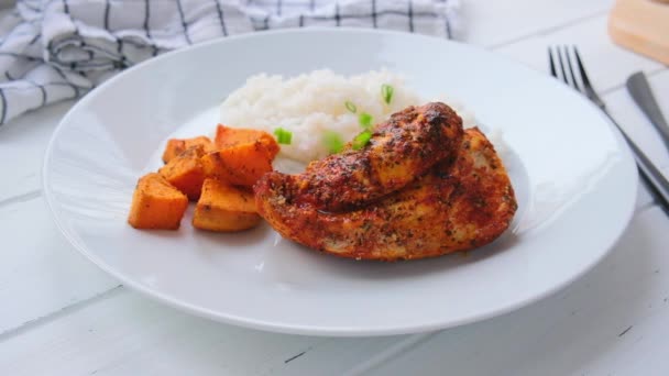 Gebackene Hühnerbrust mit Reis und Süßkartoffeln auf weißem Teller. Ernährungskonzept. — Stockvideo