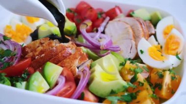 Tavuk, avokado, yumurta, domates ve soğanlı Amerikan salatası. Amerikan mutfağı kavramı.