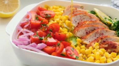 Beyaz tabakta mısır ve domatesli tavuk göğsü salatası. Sağlıklı gıda konsepti..
