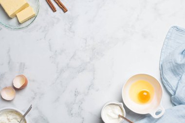 Tatlı pişirme konsepti. Taze ham malzemeler: yumurta, krema, beyaz arka planda tereyağı, fotokopi alanı. Pişirme için arkaplan çerçevesi.