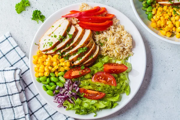 白いプレート 灰色の背景に玄米や野菜と鶏の胸肉を焼きます 健康食品のコンセプト — ストック写真
