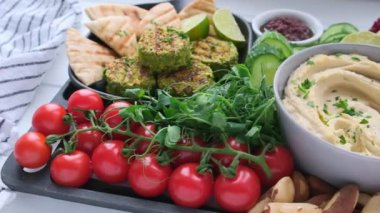 Vejetaryen şarküteri tahtası. Sebzeli humus kasesi, kızarmış nohut, zeytin, falafel ve ekmek..