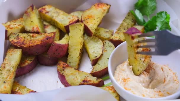 Comer batatas horneadas en plato de horno blanco con hummus. — Vídeo de stock