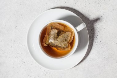 Beyaz bardakta taze bitki çayı. Bitki çayı poşetleri..