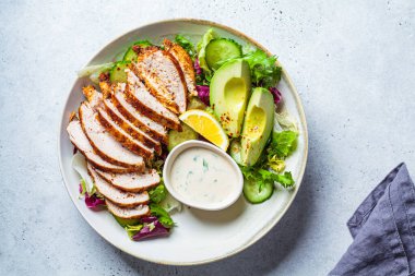 Avokado, salatalık ve mayonez soslu ızgara tavuk göğsü salatası. Sağlıklı gıda konsepti.