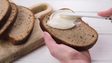 Kadın elleri krem peynirli tost pişiriyor. 