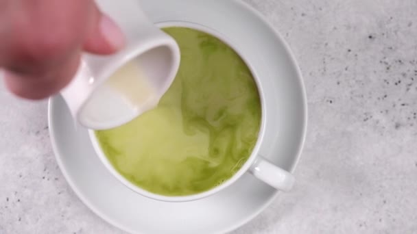 Mão derrama leite de aveia no chá matcha — Vídeo de Stock