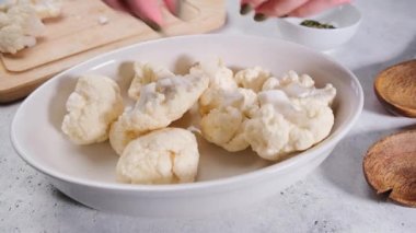 Masada baharat ve yağ ile çiğ karnabahar pişirmek. Vejetaryen yemekleri pişirmek. 