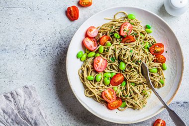 Domatesli ve fasulyeli yeşil vejetaryen edamame makarna. Bitki temelli diyet kavramı.