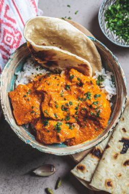 Baharatlı soslu tavuk tikka masala pilav ve chapati ekmeği, koyu arkaplan. Hint mutfağı konsepti.