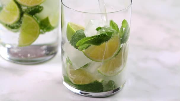 Wlać wapno i wodę miętową do szklanki. Gotowanie mojito. — Wideo stockowe