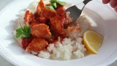 Domates soslu kızarmış tavuk ve beyaz tabakta pilav yemek.