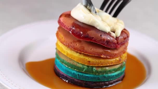 Comer panqueques arco iris con crema y jarabe. — Vídeo de stock