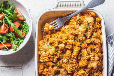 Fırında tavuk ve peynirli fırında makarna, gri arka plan. İtalyan mutfağı kavramı.