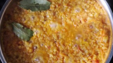 Vejetaryen mercimek çorbasını tencerede kaynatıyorlar. Hint mutfağı konsepti.