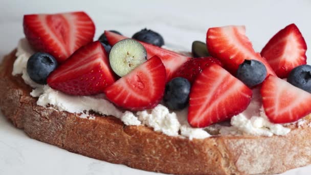 Tostadas con queso crema, fresas, arándanos y jarabe. — Vídeo de stock