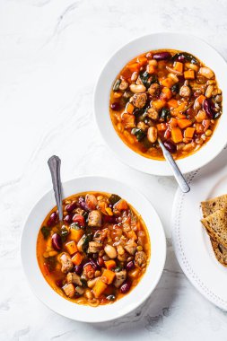 Beyaz tabakta sosisli fasulye çorbası, beyaz mermer arka plan. İtalyan mutfağı kavramı.