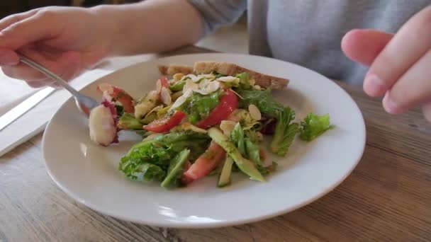 Gadis tangan makan salad hijau segar di kafe. Makan siang sehat dalam konsep kafe. — Stok Video