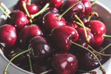 Fresh summer cherries in a gray bowl, close-up.