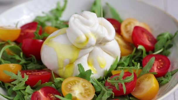 Burrata cheese salad with arugula and tomatoes pouring with oil, slow motion. — Wideo stockowe